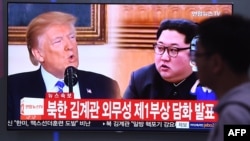 A man walks past a television news screen showing North Korean leader Kim Jong Un, right, and U.S. President Donald Trump, left, at a railway station in Seoul, South Korea, May 16, 2018.