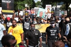 FILE - People gather for a civil rights National Association for the Advancement of Colored People (NAACP) protest march, June 15, 2020 in Atlanta, Georgia.