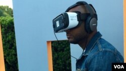Duane Rollins of Washington, D.C., tries an exhibit that simulates solitary confinement. He said "It takes away your humanity," he said. (M. Salinas/VOA)