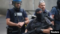 FILE - French police and anti-crime brigade members secure a street during a counterterrorism exercise at different locations in Argenteuil, a suburb north of Paris, July 21, 2016.