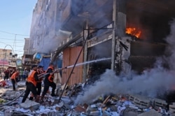Palestinian firefighters battle a blaze following an Israeli strike on the town of Rafah in the southern Gaza Strip, May 15, 2021.