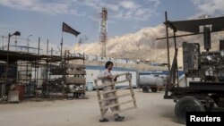 FILE - An Iranian laborer works at a unit of South Pars Gas field in Asalouyeh Seaport, north of Persian Gulf, Iran.