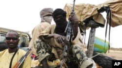 Militiamen from the Ansar Dine Islamic group sit on a vehicle in Gao in northeastern Mali, June 18, 2012. 