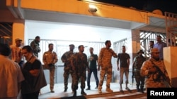 Las fuerzas de seguridad hacen guardia afuera del edificio que fue atacado por un grupo de manifestantes en Benghazi 28 de septiembre 2012. 