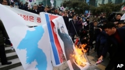 South Korean protesters burn a portrait of North Korean leader Kim Jong Un during a rally against a visit of North Korean Hyon Song Wol, head of North Korea's art troupe, in front of Seoul Railway Station in Seoul, Jan. 22, 2018.