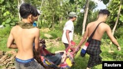 Displaced people carry a sick person in eastern Myanmar's Kayah State, June 17, 2021.