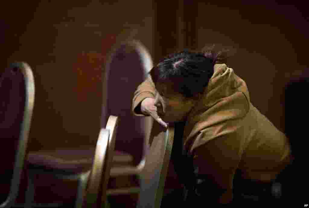 A Chinese relative of passengers aboard a missing Malaysia Airlines plane watches TV as she waits for the latest news in a hotel room in Beijing, China, March 13, 2014. 