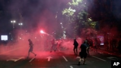Protesters clash with riot police on the steps of the Serbian parliament during a protest in Belgrade, Serbia, July 10 2020.