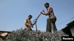 Workers flatten metal scrap on a supply truck at an industrial area in Mumbai, India, November 30, 2018. 