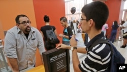 FILE - Job applicant Lazaro Fonte, right, 24, of Miami, talks with Banana Republic assistant manager Edward Ortega, during a job fair at Dolphin Mall in Miami. 