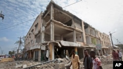 Men walk near destroyed buildings as thousands of Somalis gathered to pray at the site of the country's deadliest attack, Oct. 20, 2017. More than 300 people were killed and nearly 400 wounded in Saturday's truck bombing. 