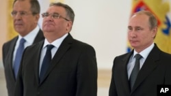 Hungary's Ambassador Janos Balla, center, and Russian President Vladimir Putin pose for a photo after the Hungarian envoy presented his credentials in the Kremlin in Moscow, Nov. 19, 2014. At left in the background is Russian Foreign Minister Sergey Lavrov.