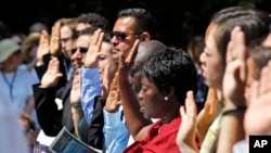 FILE - Candidates for naturalization take the Oath of Citizenship during a ceremony at George Washington's Mount Vernon estate, July 4, 2012, in Alexandria, Virginia.