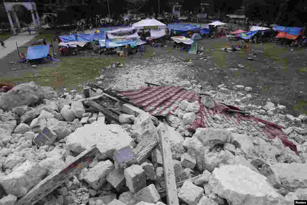 Residents stay in makeshift shelters near the rubble of the centuries-old Our Lady of Light church in Loon, Bohol, a day after an earthquake, Philippines, Oct. 16, 2013. 