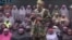 This undated image taken from video distributed Sunday, Aug. 14, 2016, shows an alleged Boko Haram soldier standing in front of a group of girls alleged to be some of the 276 abducted Chibok schoolgirls held since April 2014, in an unknown location.