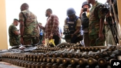 FILE - Journalists look at arms and ammunition which military commanders say they seized from Islamic fighters, in Maiduguri, Nigeria, June 5, 2013.