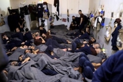 FILE - Foreign prisoners, suspected of being part of the Islamic State, lie in a prison cell in Hasakeh, Syria, Jan. 7, 2020.