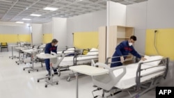 FILE - Iranian workers setting up a makeshift hospital inside the Iran Mall, northwest of Tehran, amid the coronavirus outbreak, March 21, 2020. 