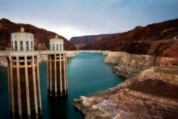FILE - In this July 28, 2014, photo, lightning strikes over Lake Mead near Hoover Dam that impounds Colorado River water at the Lake Mead National Recreation Area in Arizona.