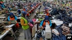 Workers sit in their stations at factory belonging to PT Eksonindo Multi Product Industry, a manufacturer of garment and bag products, in Bandung, West Java province, Indonesia, on July 11, 2024.