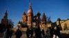 FILE - People walk on the Red Square next to St. Basil's Cathedral and the Spasskaya tower of the Kremlin on a sunny day in Moscow, Nov. 26, 2024. 