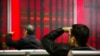 FILE - In this Oct. 31, 2018, photo, Chinese investors monitor stock prices at a brokerage house in Beijing. 