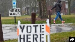 FILE - A voter braves a cold rain running to cast a ballot during the spring election, April 2, 2024, in Fox Point, Wisconsin.