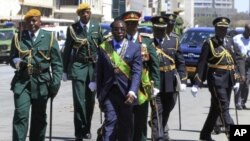 Zimbabwe's President Robert Mugabe, (C) surrounded by military officers, leaves after opening the 4th Session of the 7th Parliament in Harare September 6, 2011. 