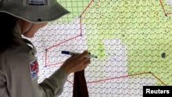 Captain Nguyen Thi Thuy of all-female landmines clearance team marks detected zones on a map of Hai Lang district, near a former U.S military base used during Vietnam War, in Quang Tri province, Vietnam March 4, 2020.
