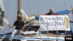 Para aktivis Yahudi di atas kapal bantuan untuk Gaza mengibarkan spanduk sebelum berangkat dari pelabuhan Famagusta, Siprus utara.