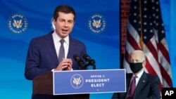 Former South Bend, Ind. Mayor Pete Buttigieg, President-elect Joe Biden's nominee to be transportation secretary reacts to his nomination as Biden looks on during a news conference at The Queen theater in Wilmington, Del., Wednesday, Dec. 16, 2020. …