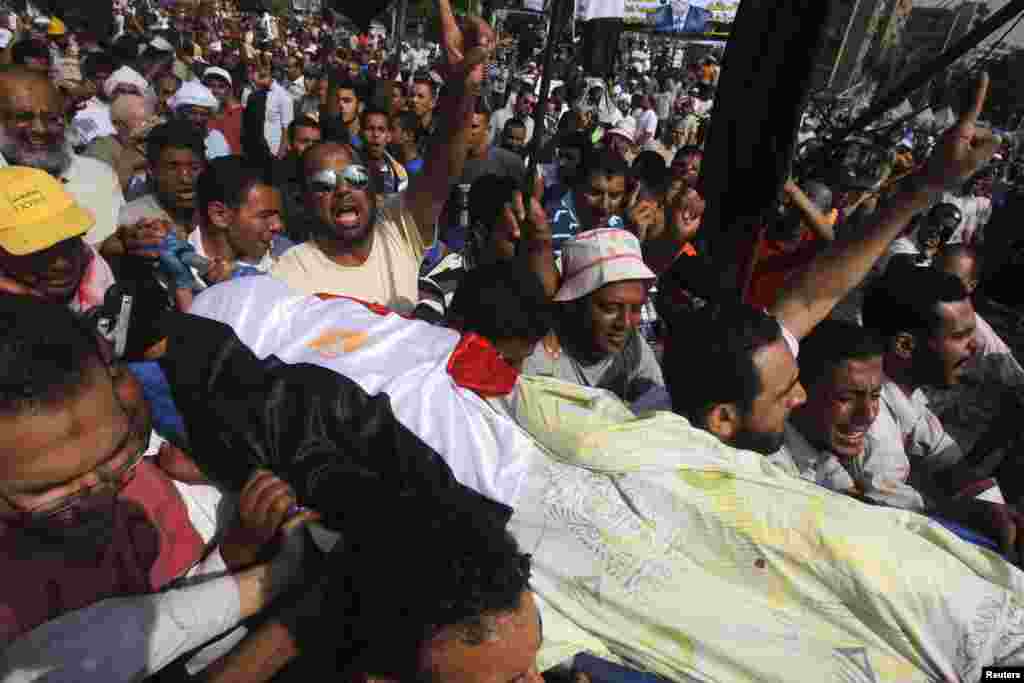 Supporters of Egypt's deposed President Mohamed Morsi carry the body of a fellow supporter killed outside the Republican Guard headquarters in Cairo, July 8, 2013.