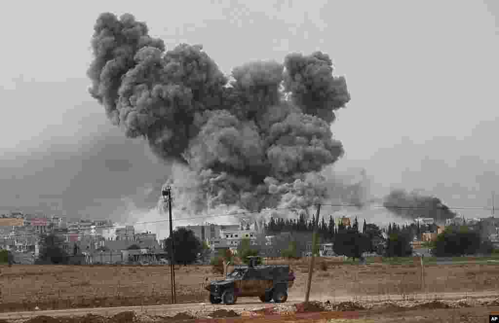 Epaisse fumée et débris s'élèvent après une frappe de la coalition menée oar les Etats-Unis à Kobani, en Syrie, dimanche le 12 ocotbre 2014. (AP Photo/Lefteris Pitarakis) 