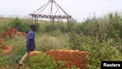 FILE - A boy walks past the ruins of the destroyed house of customary chief Kamuina Nsapu, whose death last August sparked months of deadly fighting between the government army and Kamuina Nsapu's militia in Tshimbulu near Kananga, March 11, 2017. 