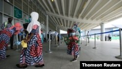A family is seen in a line at the domestic wing of the Nnamdi Azikiwe International Airport on its reopening day for domestic flight operations, following the coronavirus disease outbreak, in Abuja, Nigeria, July 8, 2020.