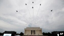 President Donald Trump, first lady Melania Trump, Vice President Mike Pence and Karen Pence and others stand as the US Army Band performs and the US Navy Blue Angels flyover at the end of an Independence Day celebration in front of the Lincoln Memorial, J