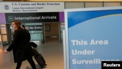 FILE - International travelers arrive at Logan Airport following a federal court's temporary stay of U.S. President Donald Trump's executive order travel ban in Boston, Massachusetts.