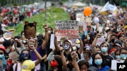 Para demonstran mengepalkan tangan mereka saat berunjuk rasa di Universitas Filipina dalam Perayaan Hari Kemerdekaan Filipina di Manila, Jumat, 12 Juni 2020.