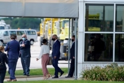 In this image taken from a motorcade, Democratic presidential candidate Joe Biden exits a building after meeting with relatives of Jacob Blake at General Mitchell International Airport, Sept. 3, 2020, in Milwaukee.