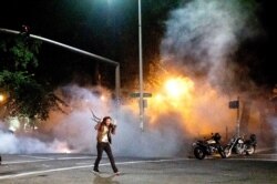 A protester walks away from chemical irritants as federal agents use crowd control munitions to disperse Black Lives Matter protesters at the Mark O. Hatfield United States Courthouse, July 19, 2020, in Portland, Oregan.