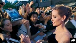 FILE - Angelina Jolie, soon to direct a film about Kenyan icon Richard Leakey, greets fans at the Tokyo premiere of "Maleficent," June 23, 2014. 