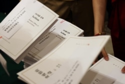 FILE - A journalist takes copies of the white paper about China's fight against the coronavirus disease before a State Council Information Office briefing in Beijing, China June 7, 2020.