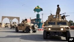 FILE - Afghan security personnel patrol in the city of Ghazni province west of Kabul, Afghanistan, Aug. 12, 2018.