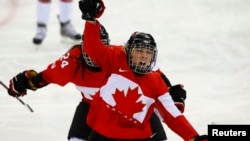 Canada's Meghan Agosta-Marciano celebrates after scoring what turned out to be the game-winning goal on Team USA's goalie Jessie Vetter (not shown) during their women's ice hockey game at the Sochi Winter Olympics, Feb.12, 2014.