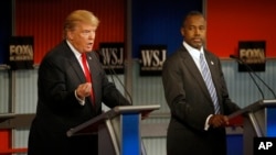 FILE - Donald Trump speaks as Ben Carson listens during the Republican presidential debate at the Milwaukee Theatre, Nov. 11, 2015, in Milwaukee, Wisconsin.