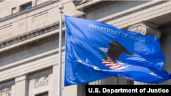 资料照片：位于华盛顿的美国司法部总部大楼外的司法部旗帜。