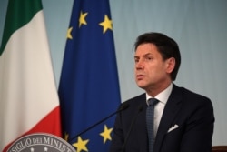 Italian Prime Minister Giuseppe Conte reacts to Italy's ruling coalition breakdown, speaking to journalists at an impromptu, late evening news conference in Rome, Aug. 8, 2019.