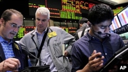 Traders work in the crude oil and natural gas options pit at the New York Mercantile Exchange in New York, (File June 29, 2011).
