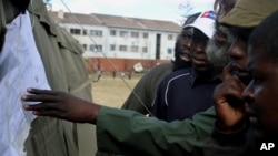 Voters look at posted results for Zimbabwe's national elections outside of a polling station in Harare August 1, 2013. 