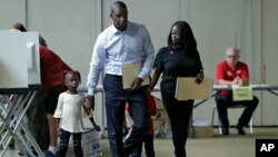 Florida Democratic gubernatorial candidate Andrew Gillum walks with his wife, R. Jai Gillum, and children Caroline and Jackson as he votes, Nov. 6, 2018, in Tallahassee, Fla. Gillum was running against Republican Ron DeSantis.